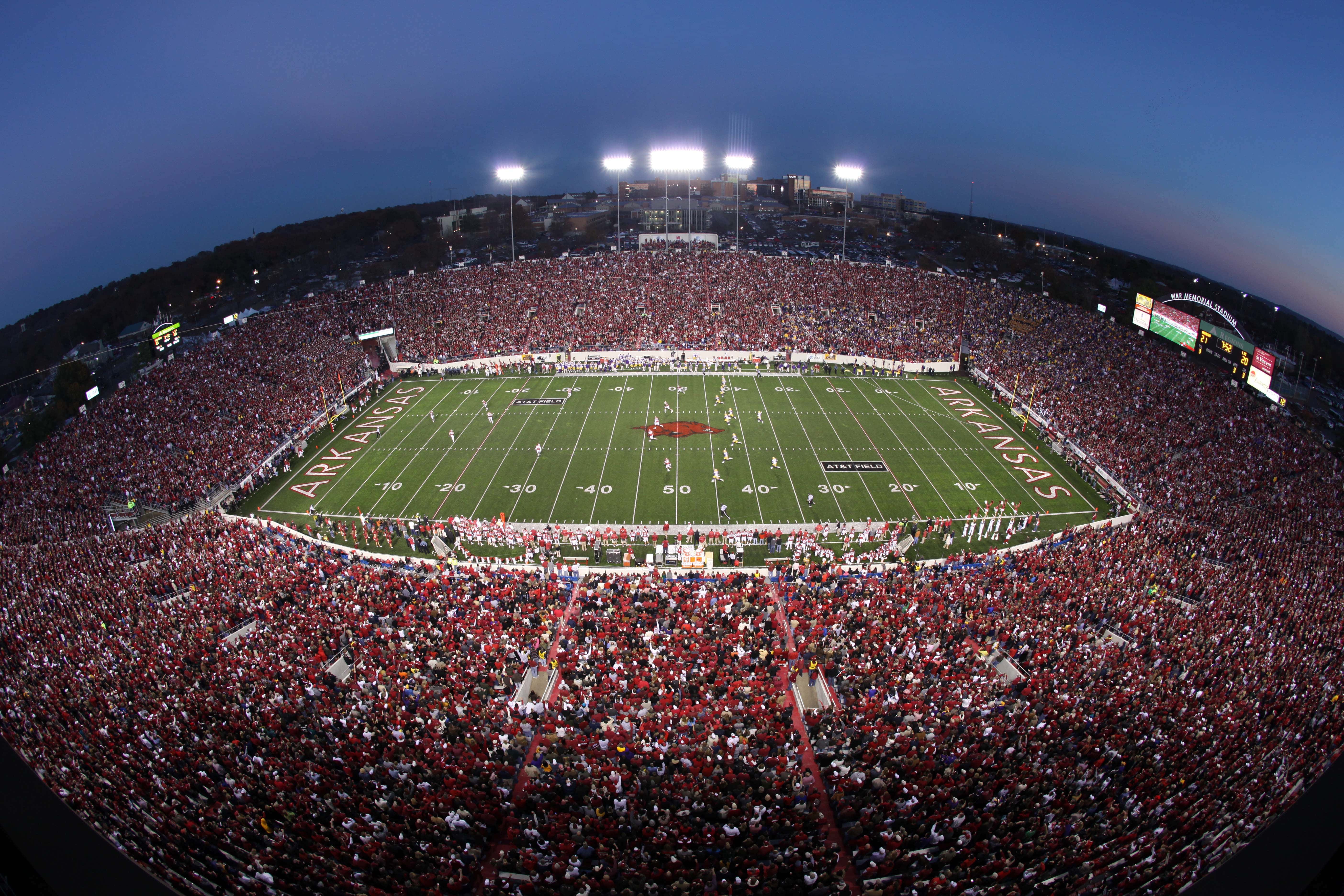 A football stadium packed with spectators during an evening game on the Arkansas field. A football stadium packed with spectators during an evening game on the Arkansas field.