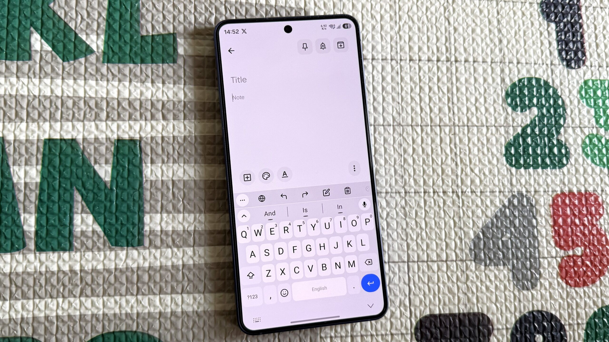 Smartphone displays an open note-taking app with active keyboard on a textured background with numbers. Smartphone displays an open note-taking app with active keyboard on a textured background with numbers.
