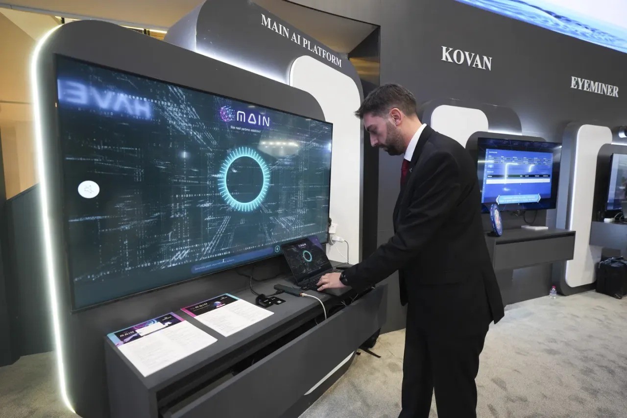 Man in suit interacts with laptop at "MAIN AI PLATFORM" exhibition booth. Man in suit interacts with laptop at "MAIN AI PLATFORM" exhibition booth.