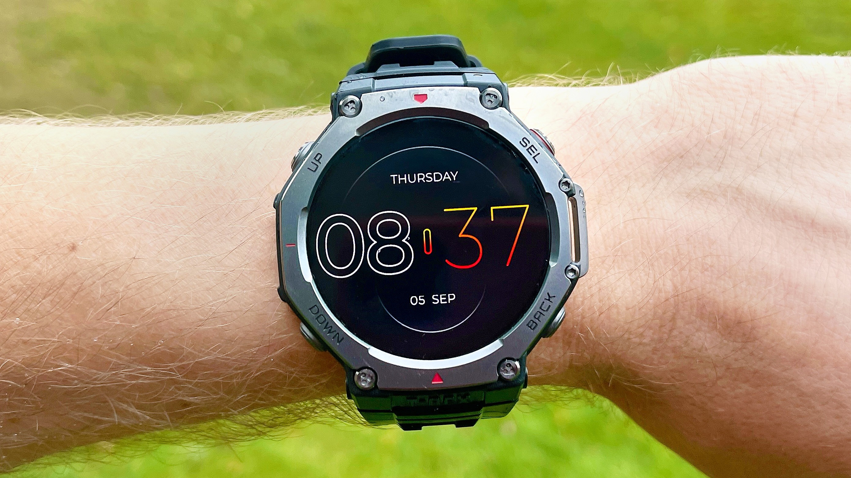 A smartwatch on a wrist displays Thursday 08:37 and 05 SEP against green grass. A smartwatch on a wrist displays Thursday 08:37 and 05 SEP against green grass.