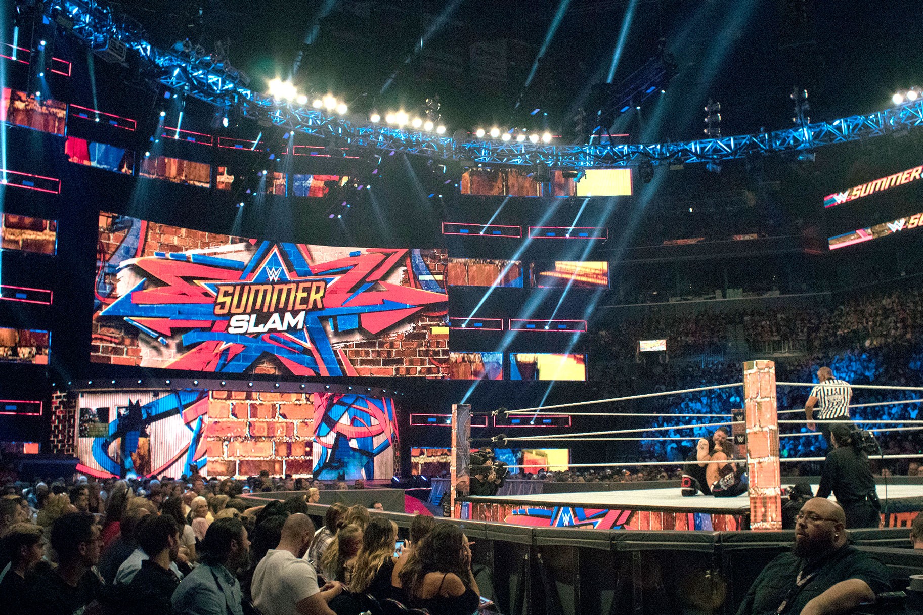 WWE SummerSlam wrestling match occurs in a packed arena with audience and screens.