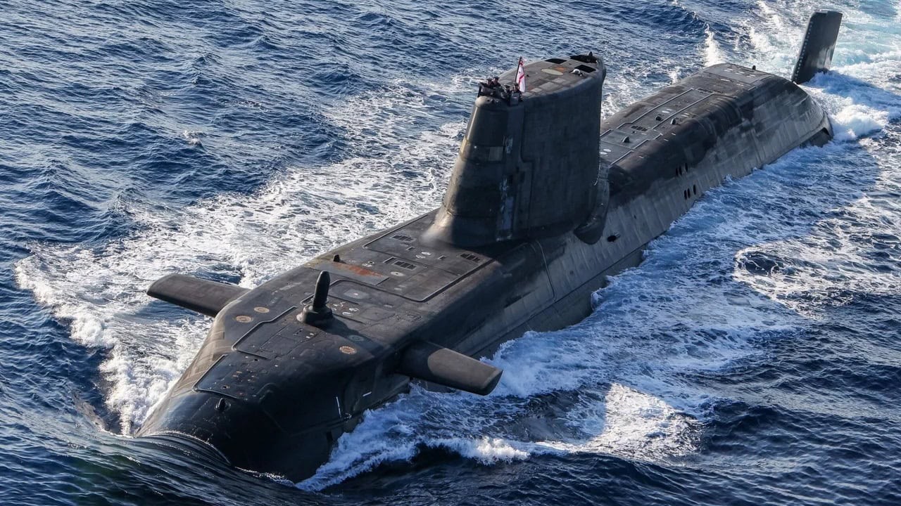A submarine surfaces in choppy blue ocean waters, creating white wake as it moves. A submarine surfaces in choppy blue ocean waters, creating white wake as it moves.