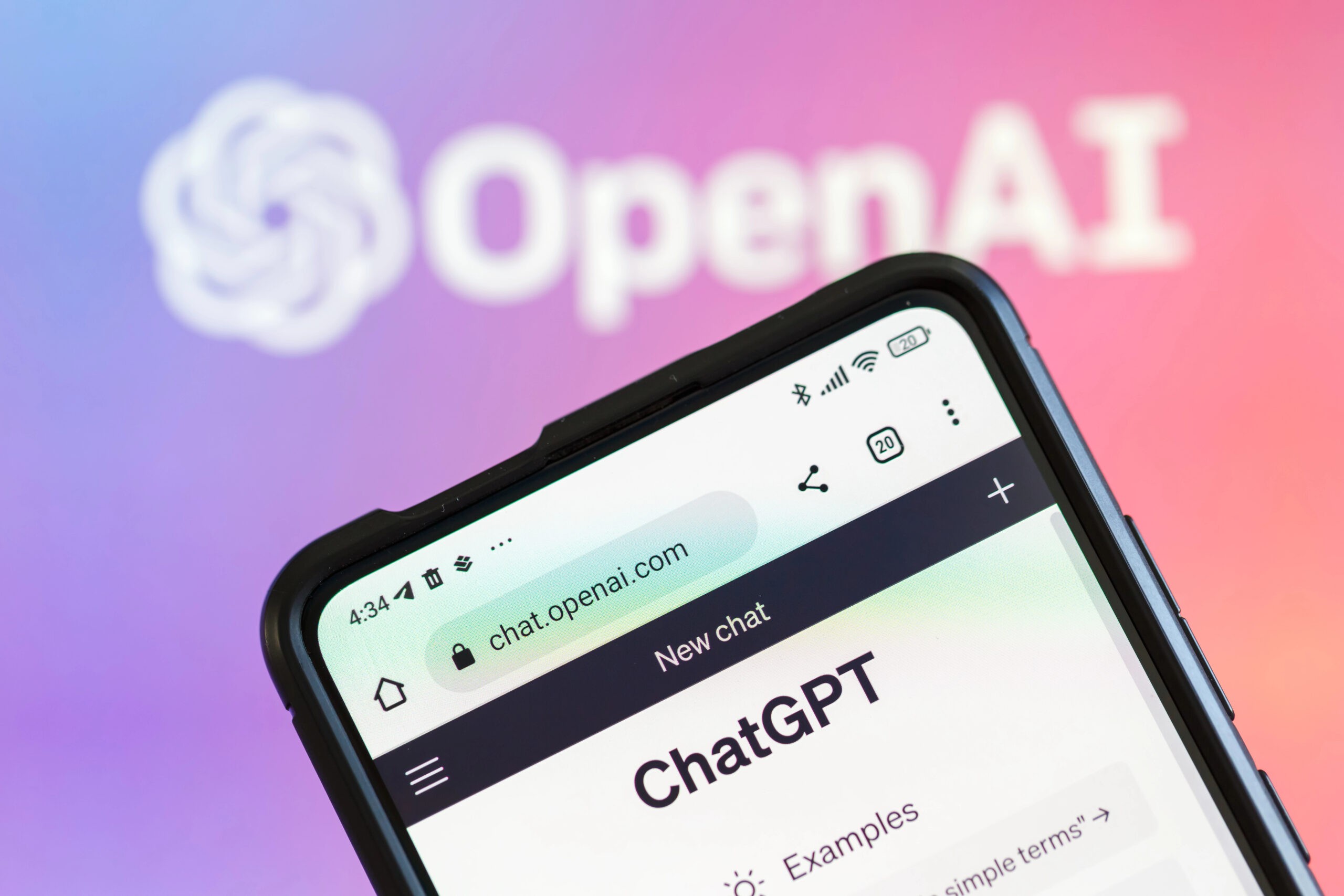 Smartphone shows ChatGPT webpage on chat.openai.com with OpenAI logo in background. Smartphone shows ChatGPT webpage on chat.openai.com with OpenAI logo in background.