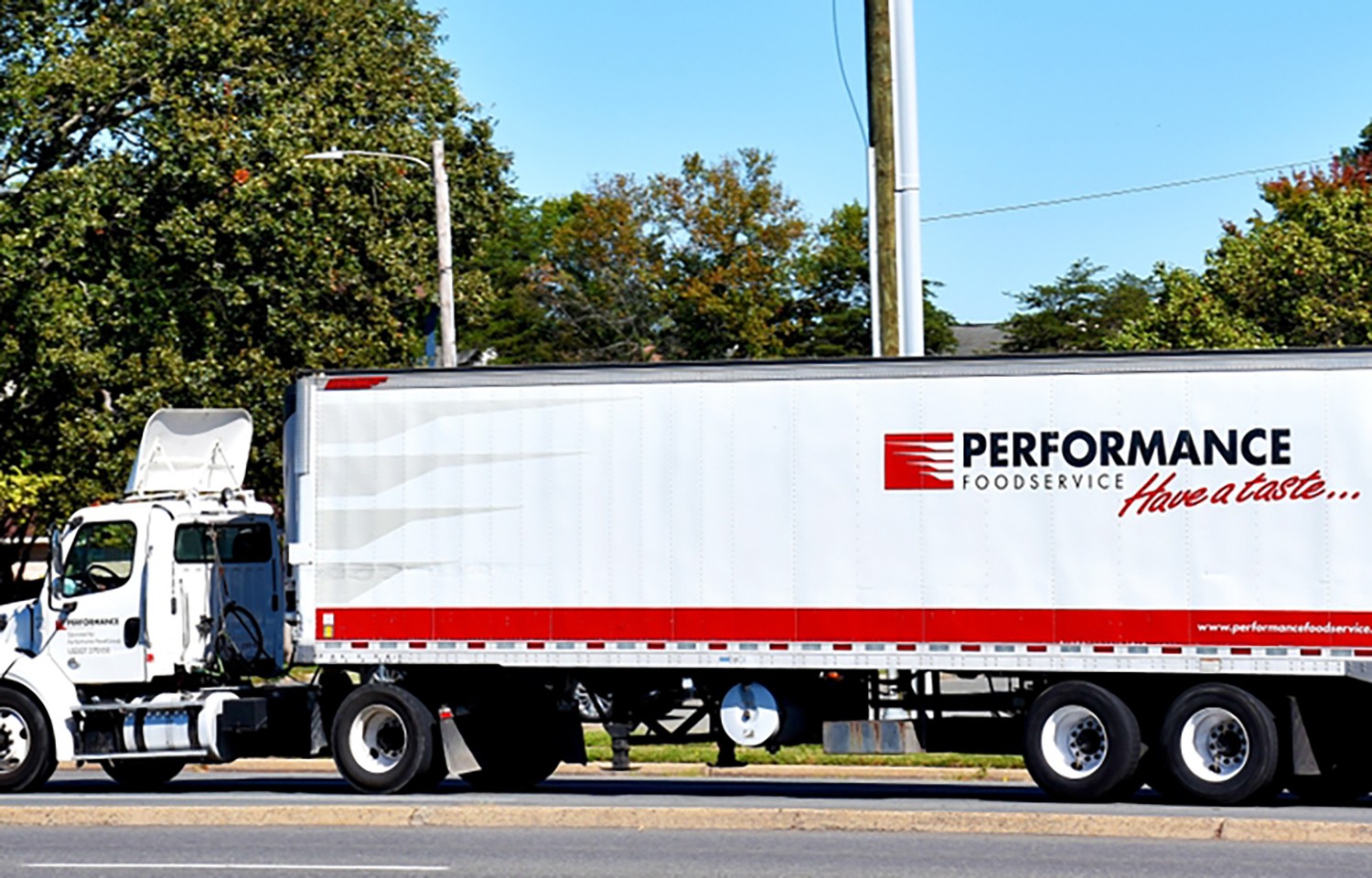 Performance Foodservice semi-truck parked on a tree-lined street. Performance Foodservice semi-truck parked on a tree-lined street.