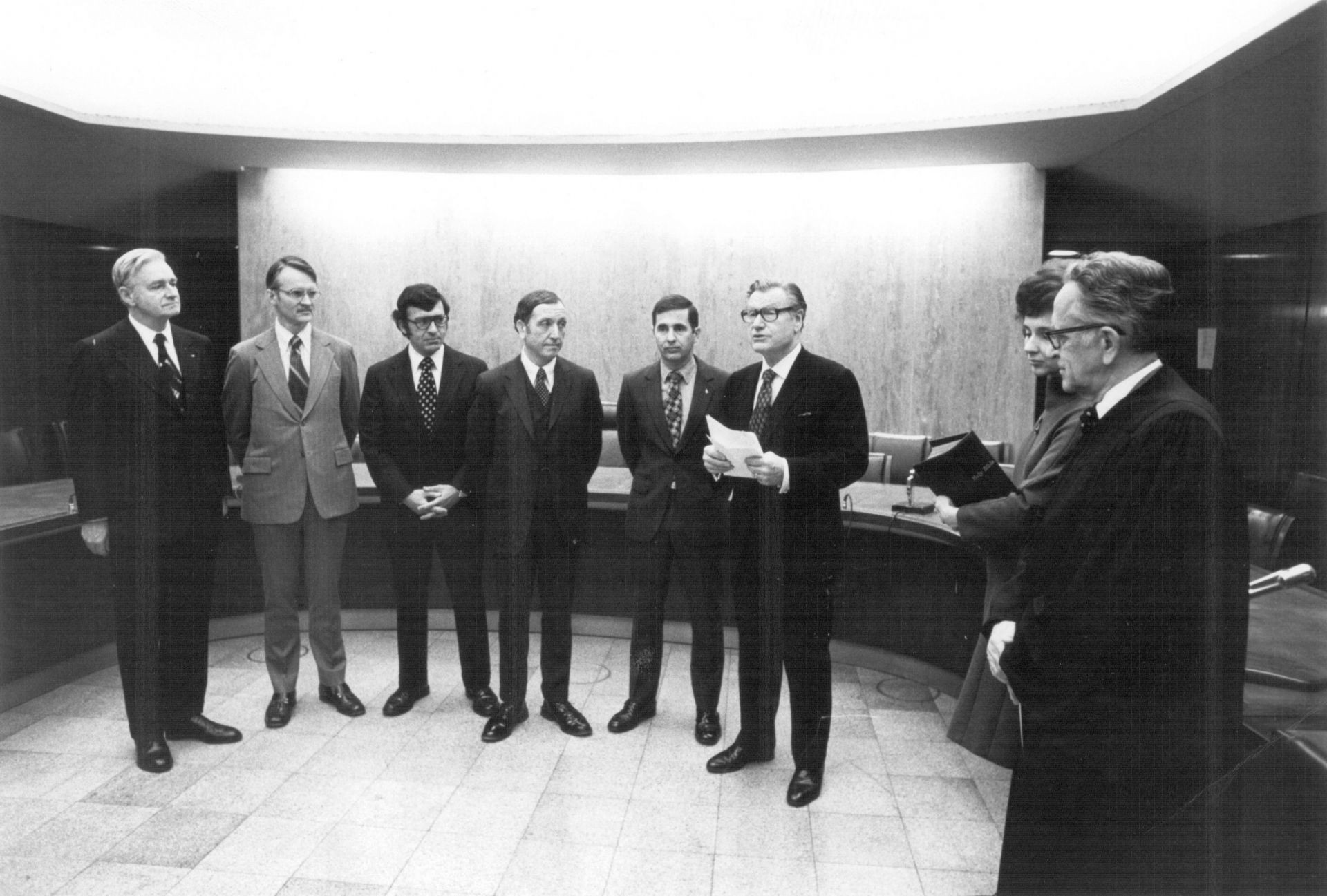 Three men pose at a U.S. Nuclear Regulatory Commission table with a framed award. Three men pose at a U.S. Nuclear Regulatory Commission table with a framed award.