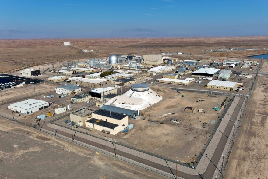 A large industrial complex with a domed building sits in an open grassy field. A large industrial complex with a domed building sits in an open grassy field.