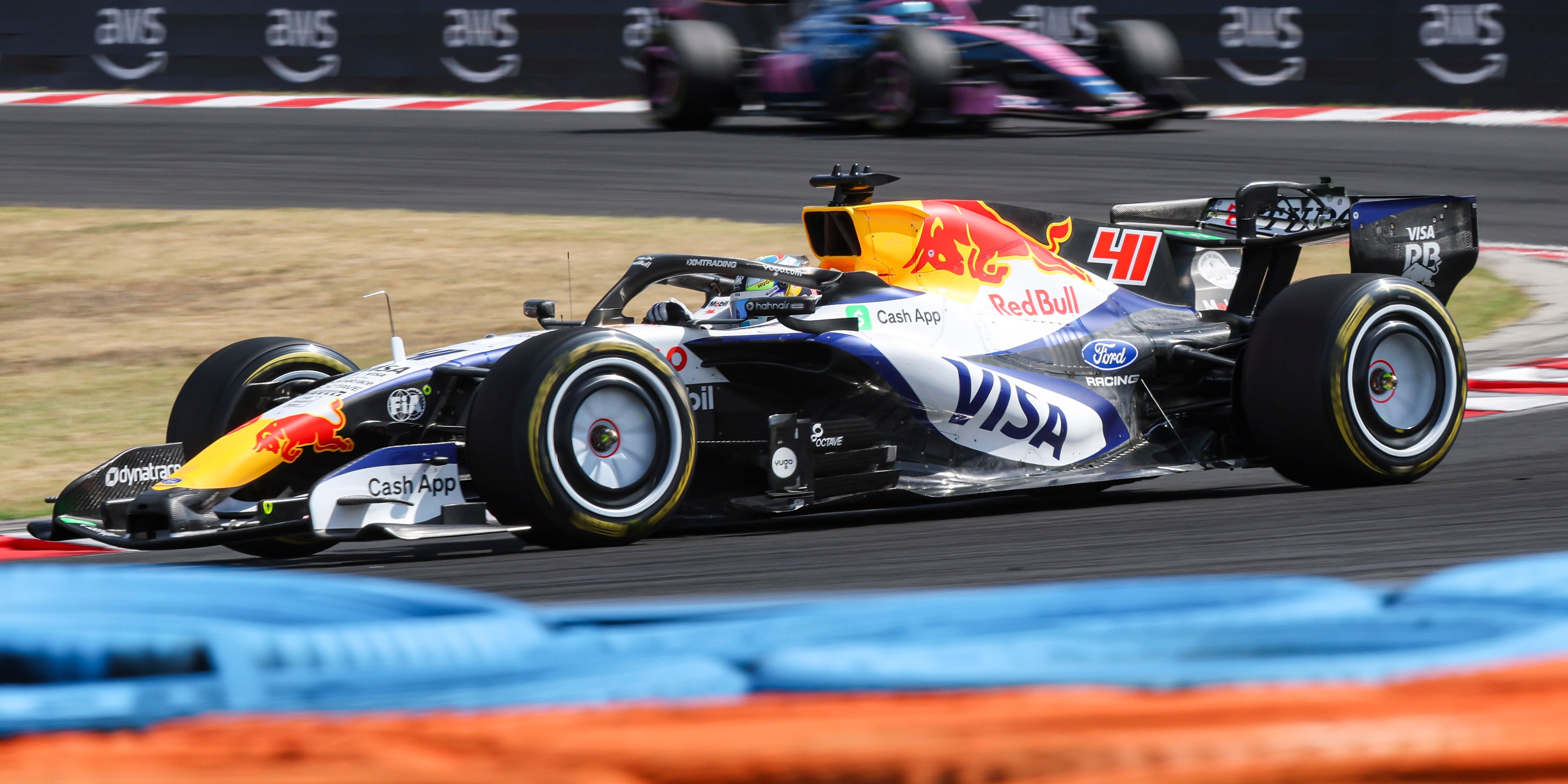 A Red Bull Racing Formula 1 car number 41 races on a racetrack with other cars visible. A Red Bull Racing Formula 1 car number 41 races on a racetrack with other cars visible.