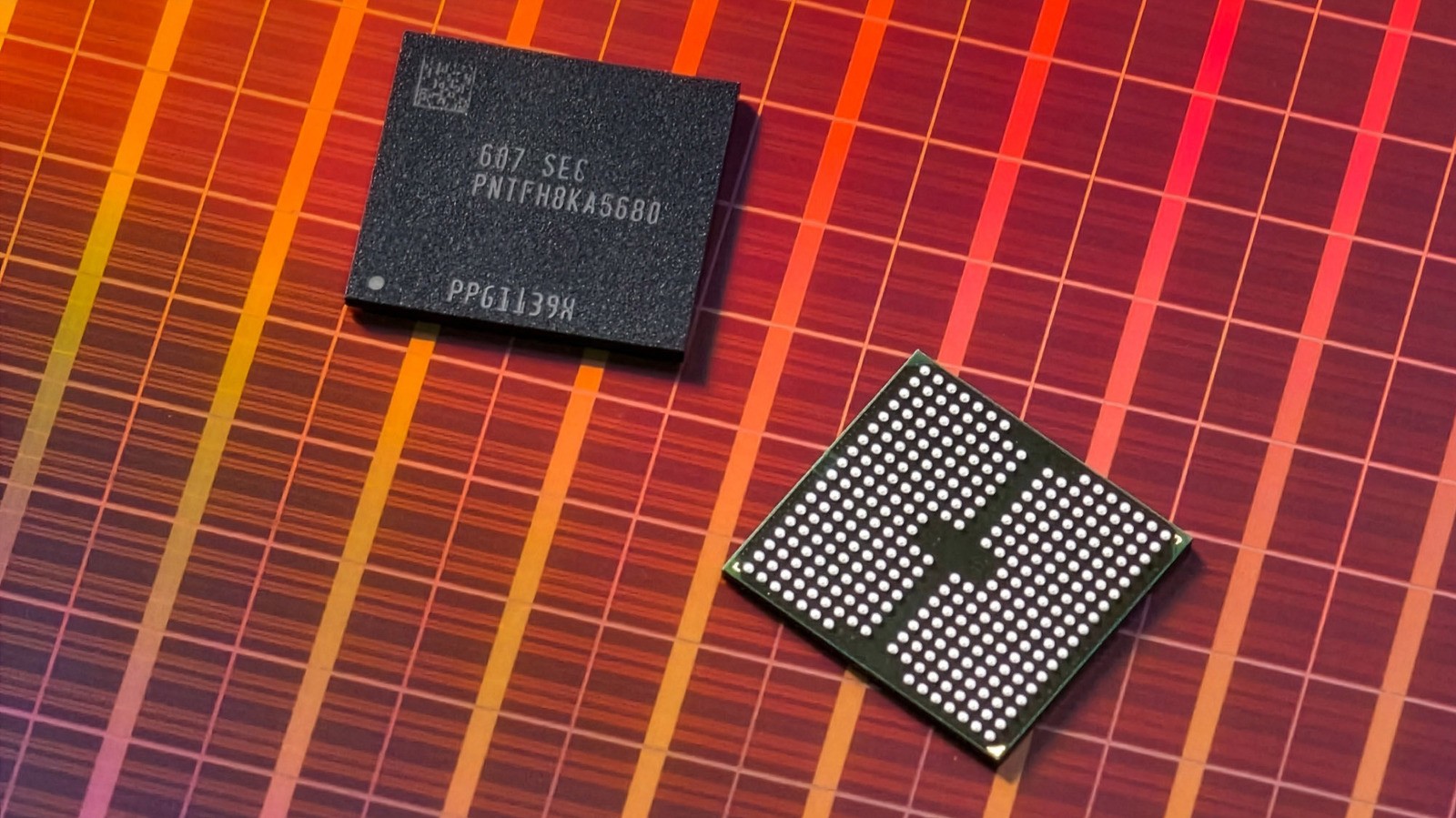 Two microchips lie on a red-orange grid-patterned surface. Two microchips lie on a red-orange grid-patterned surface.