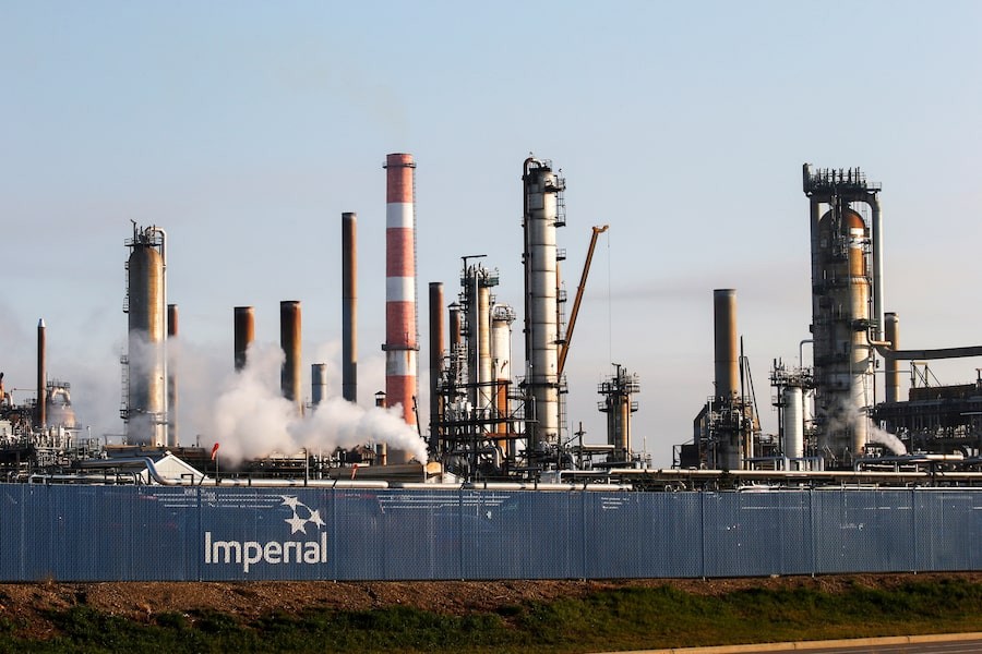 Imperial oil refinery emits steam from its industrial complex of towers and structures. Imperial oil refinery emits steam from its industrial complex of towers and structures.